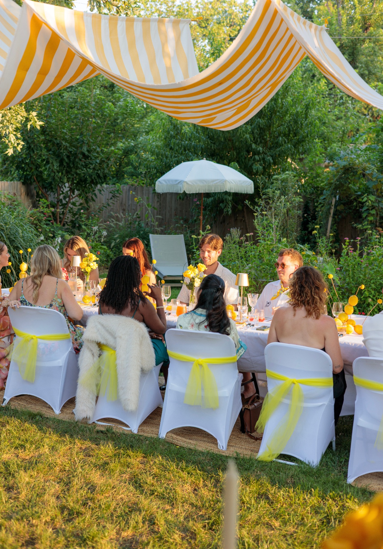 Gardanne long-table dinner under a yellow-striped canopy